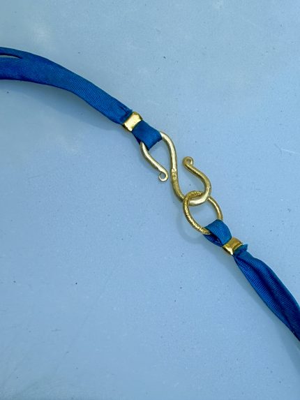 Ανακαλύψτε το χειροποίητο κολιέ 'Azure Tie' της Melia. Ένα statement κόσμημα 76cm με μαργαριτάρια γλυκού νερού και μπλε μεταξωτή κορδέλα. Αγόρασε online!
