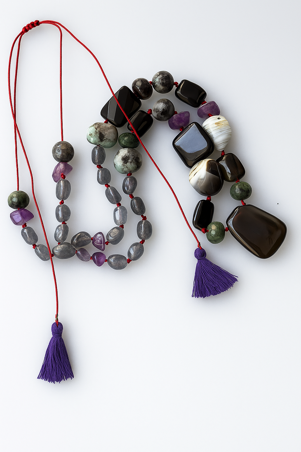 Κολιέ Melia Soul Stone Journey One of a Kind Χειροποίητο κολιέ με ημιπολύτιμες πέτρες Melia Soul Stone Journey, one of a kind, με αμέθυστο, όνυχα, αχάτη, ζοϊσίτη, λαβραδορίτη και κόκκινο νήμα με μωβ φούντα.