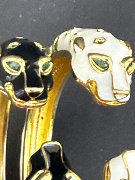 Σύνθεση από δύο βραχιολια ατσαλι πουμα melia "Panthera", ένα λευκό και ένα μαύρο, με κεφαλές πούμα και πράσινες πέτρες, σε ουδέτερο φόντο. (Focus Keyword: βραχιολια ατσαλι πουμα melia)