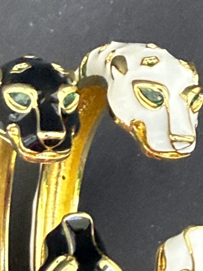 Σύνθεση από δύο βραχιολια ατσαλι πουμα melia "Panthera", ένα λευκό και ένα μαύρο, με κεφαλές πούμα και πράσινες πέτρες, σε ουδέτερο φόντο. (Focus Keyword: βραχιολια ατσαλι πουμα melia)