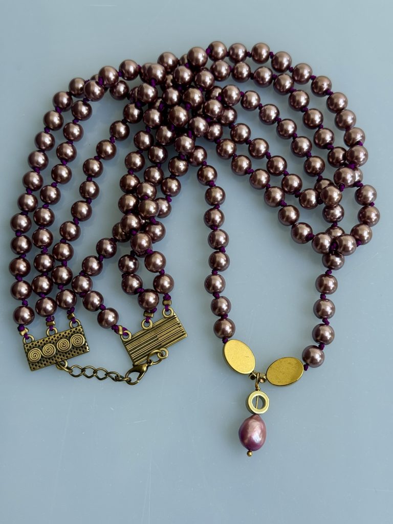 Κολιέ τριπλή σειρά πέρλες Melia Triple Vintage (60cm) σε μπρονζέ-χρυσό χρώμα με vintage κούμπωμα.