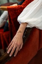 Γυναικείος καρπός που φοράει το κεντημένο μαρτάκι της Funny Granny, συνδυασμένο με casual ανοιξιάτικο στυλ, αναδεικνύοντας την εφαρμογή και το μέγεθος του κοσμήματος.